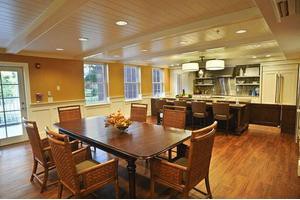 A cozy dining area with a wooden table, chairs, and an open kitchen layout.