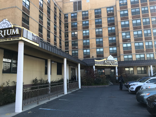 A view of the exterior of a hotel featuring a multi-story building with a parking area in front.