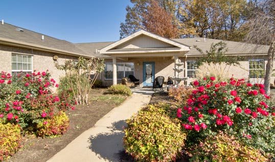 A welcoming home entrance with a well-maintained garden and blooming flowers lining the pathway.