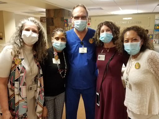 A group of healthcare professionals posing together in a hospital setting, all wearing masks.