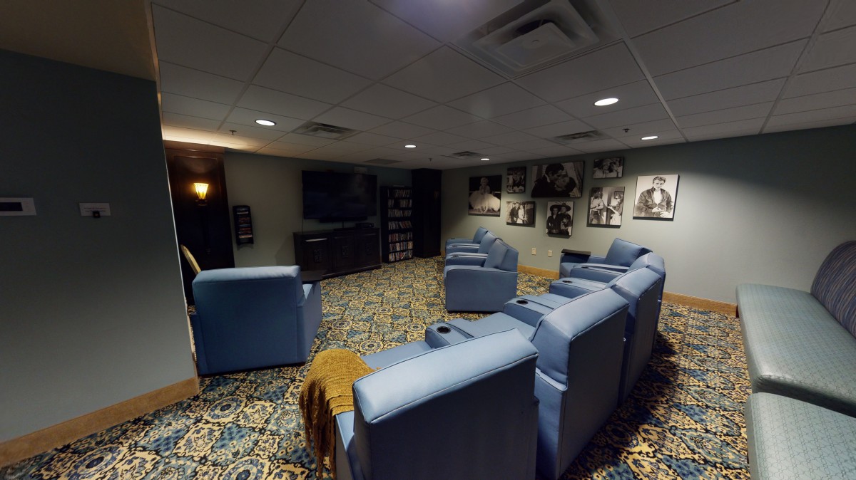 A cozy home theater setup with comfortable chairs and a large TV screen.