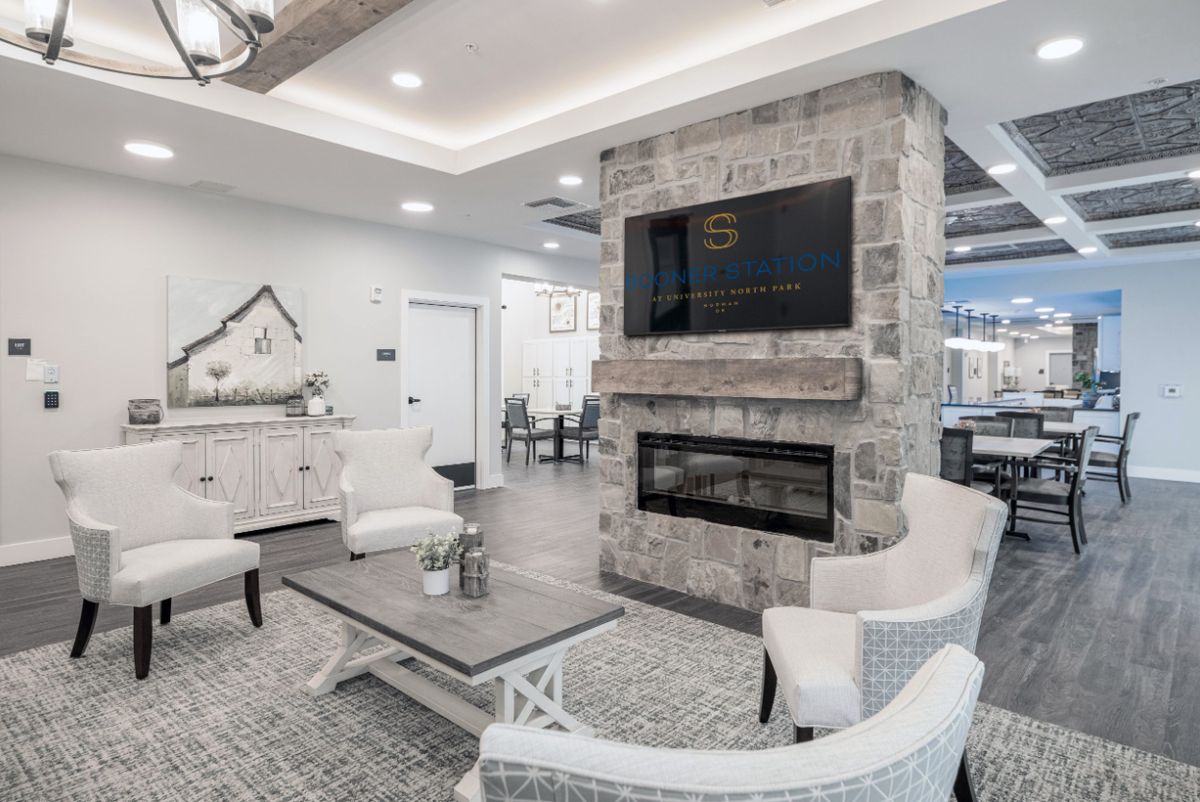 A modern, elegant living room with a stone fireplace and comfortable seating.