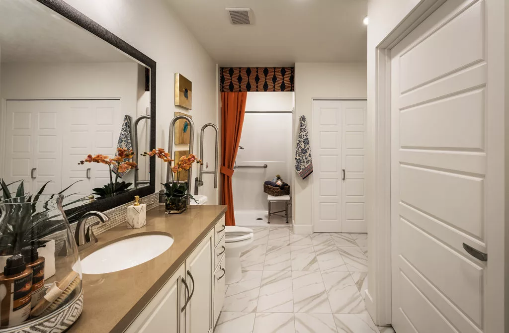 A modern bathroom with double sinks and a marble floor.