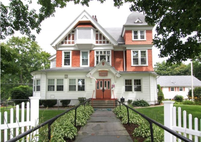 A charming Victorian-style house with a well-maintained garden and pathway.
