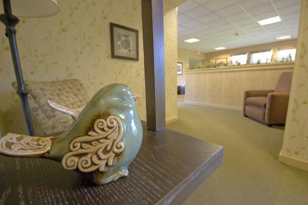 A cozy waiting room decorated with a ceramic bird sculpture and comfortable seating.
