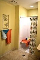 A cozy bathroom with colorful towels and a patterned shower curtain.