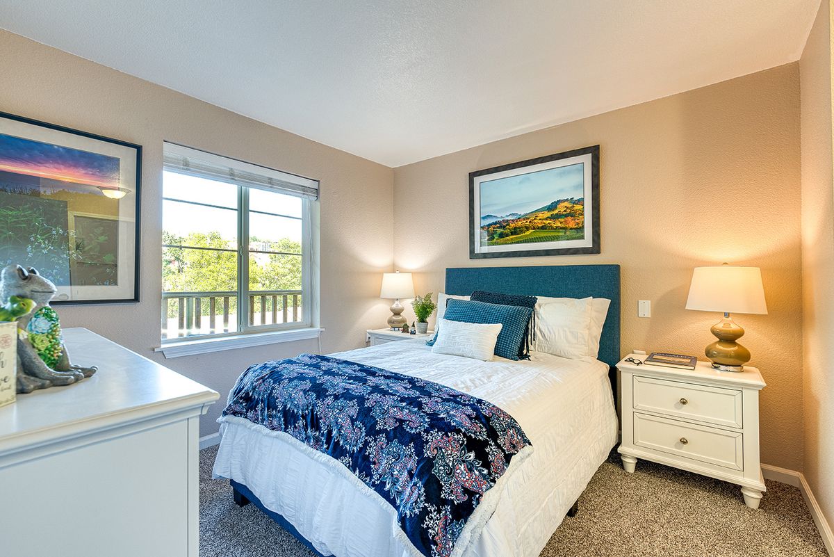 A cozy bedroom with a neatly made bed and soft lighting.