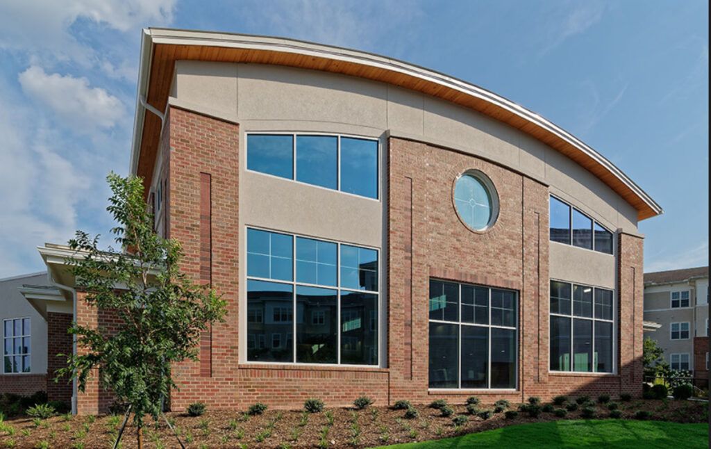 A modern commercial building featuring a brick facade and large windows.