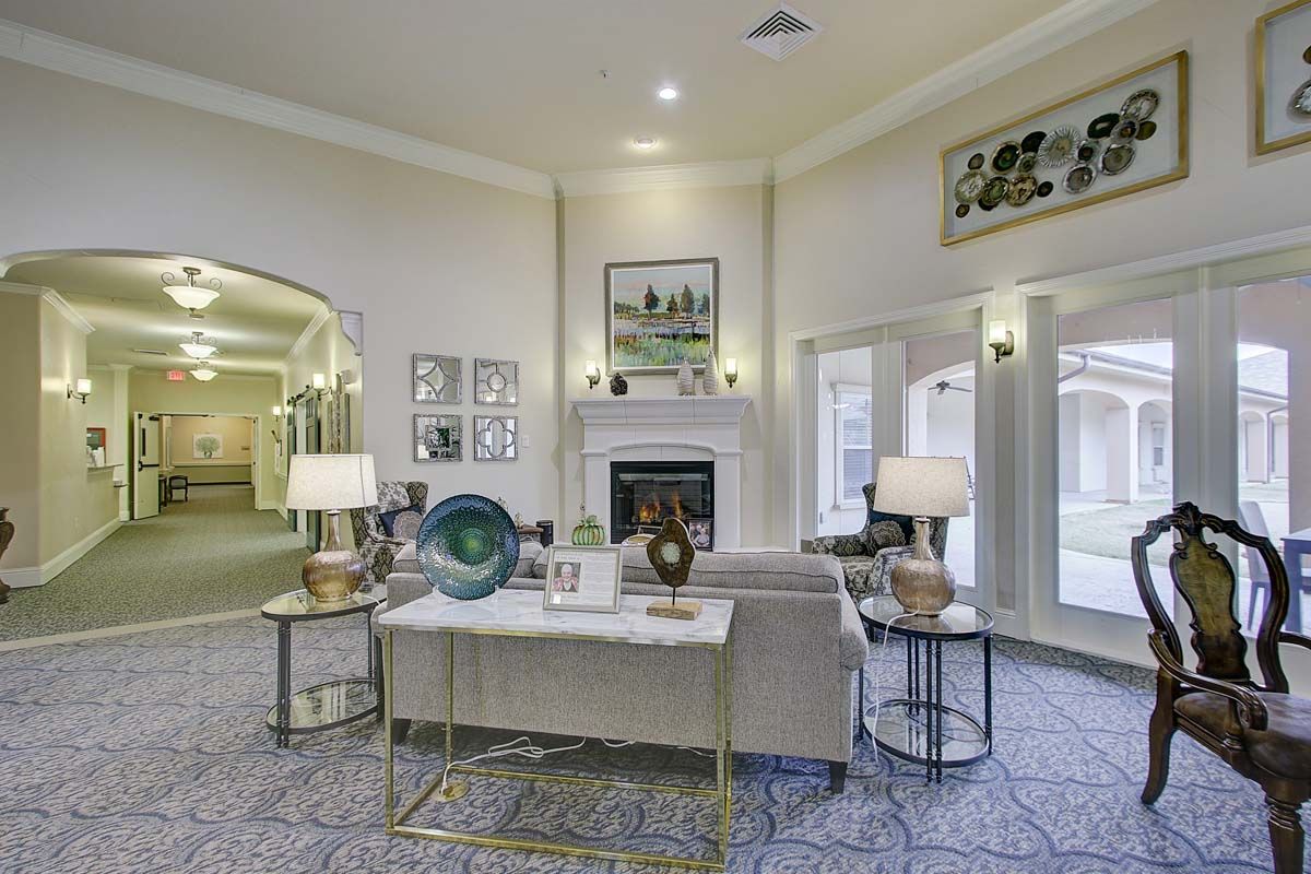 A modern living room featuring elegant decor, a central fireplace, and ample natural light from large windows.