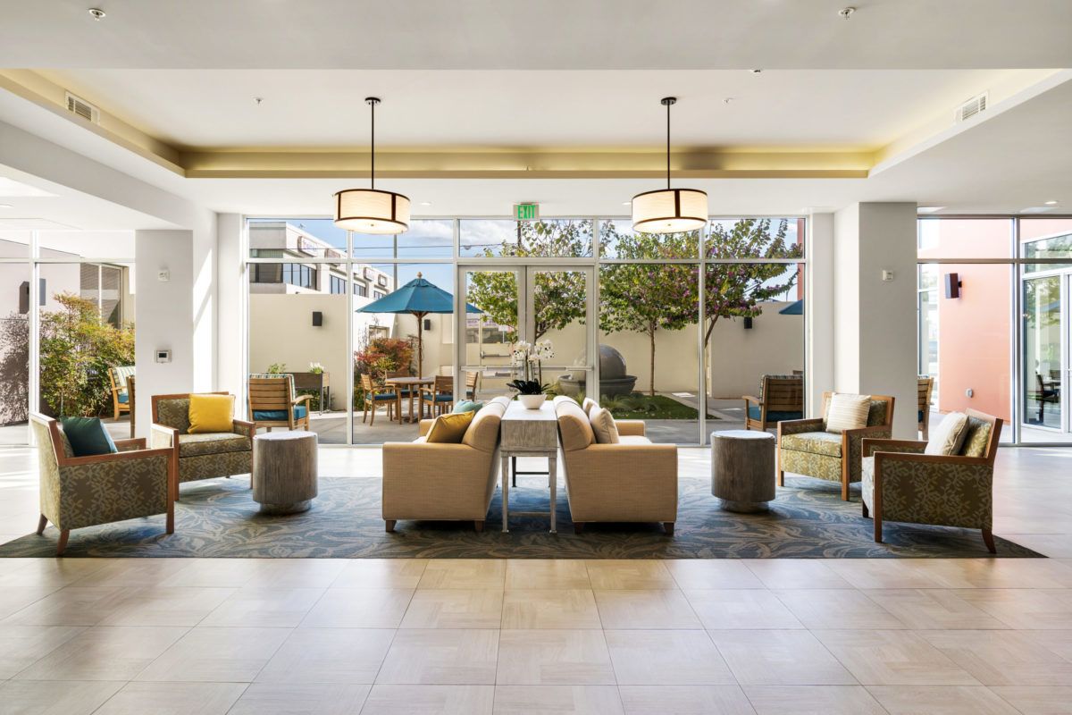 A modern hotel lobby with comfortable seating and large windows allowing natural light.