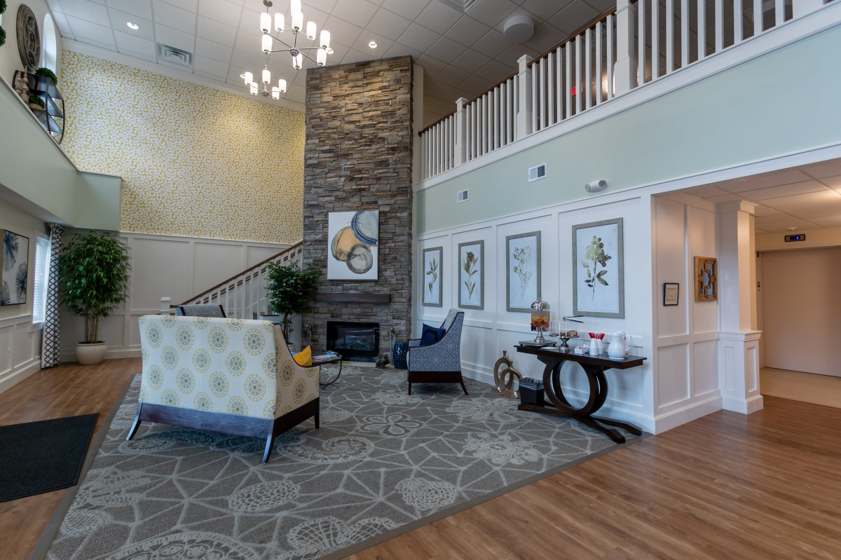 A stylish lobby area with elegant furnishings, artwork, and a chandelier.