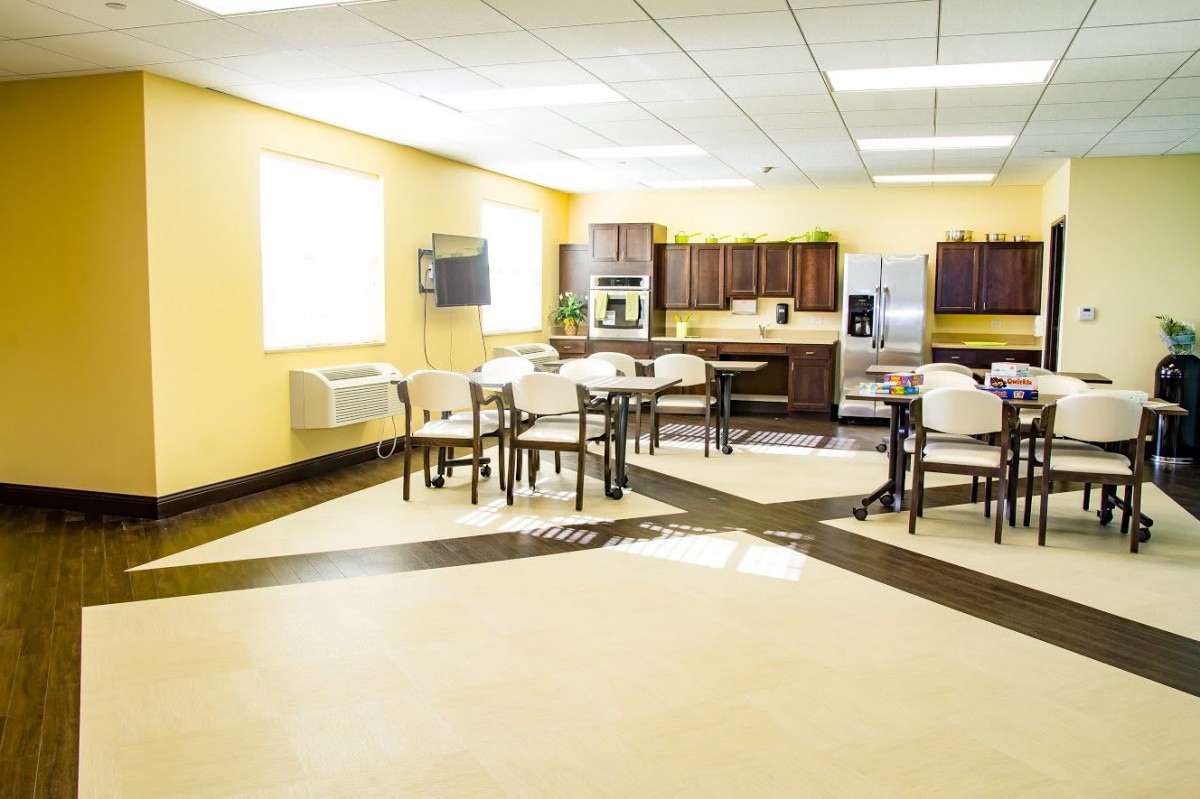 A spacious kitchen and dining area with modern appliances and yellow walls.