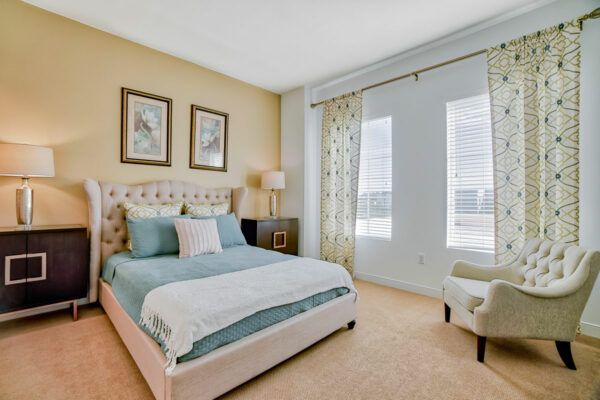 A well-decorated bedroom with a large bed, elegant curtains, and tasteful decor.