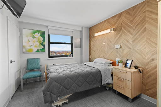 A modern and minimalist bedroom featuring two beds, a wooden accent wall, and a view.