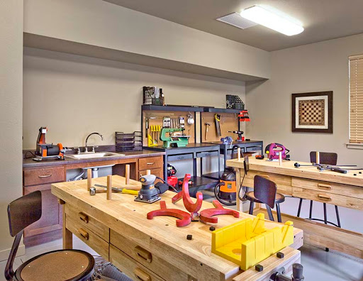 A well-equipped workshop featuring various tools and workbenches, ideal for woodworking and crafting projects.