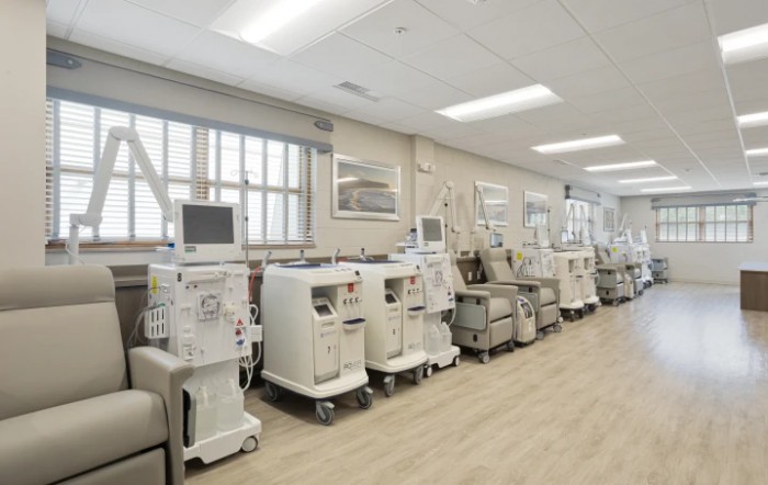 A hospital room filled with dialysis machines arranged in a row.