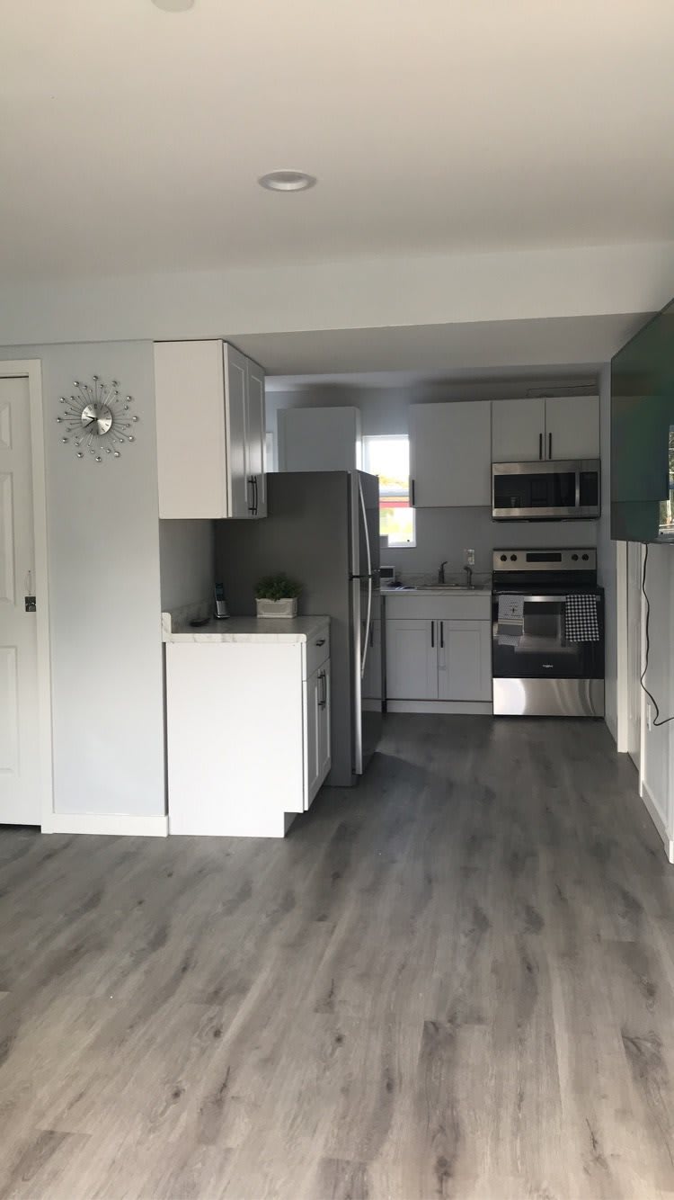 A modern kitchen with white cabinetry and stainless steel appliances.