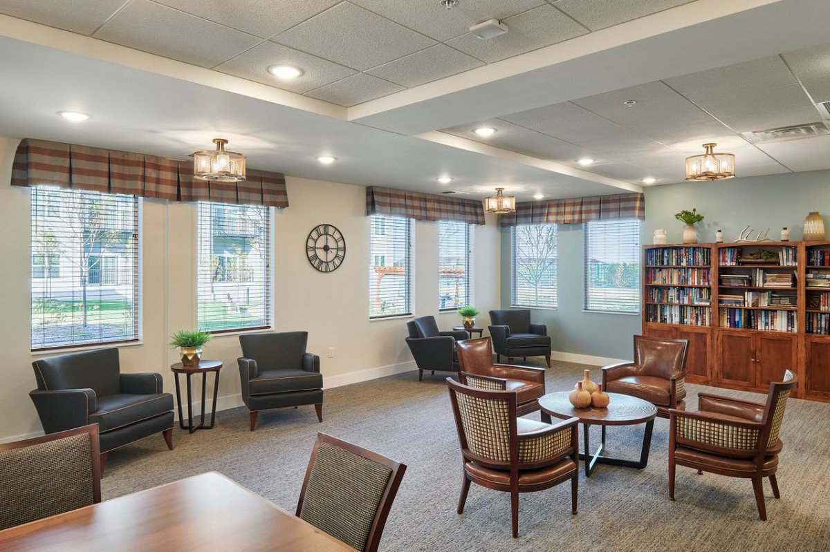 A cozy, well-lit living room with comfortable seating and large windows, perfect for relaxation.