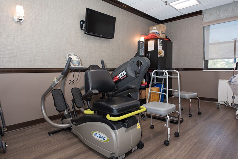 A physical therapy room equipped with exercise machines and rehabilitation aids.