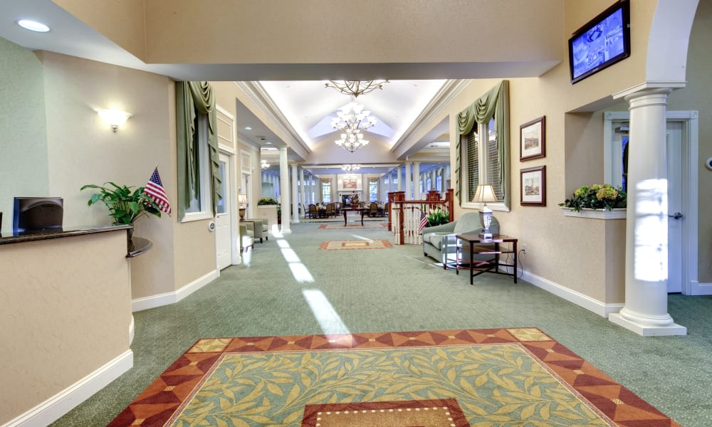 A well-lit lobby area with elegant chandeliers, carpeted flooring, and comfortable seating.