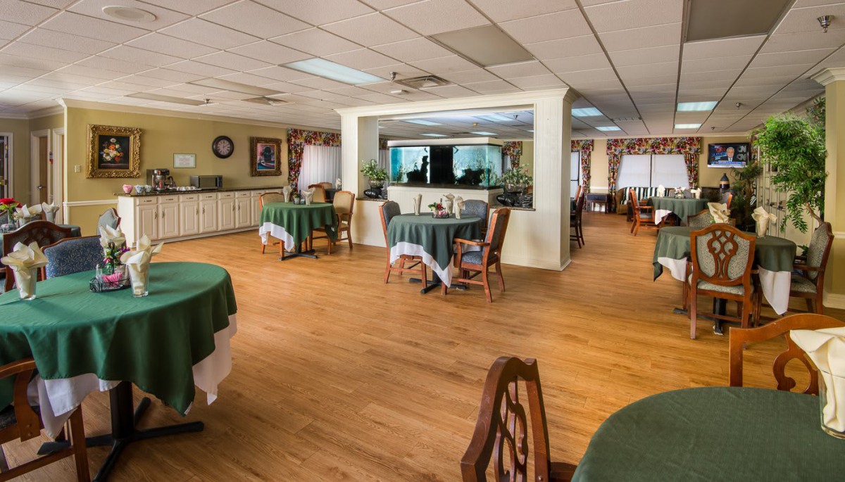 A spacious dining room with neatly arranged tables and chairs, featuring a warm and inviting interior design.