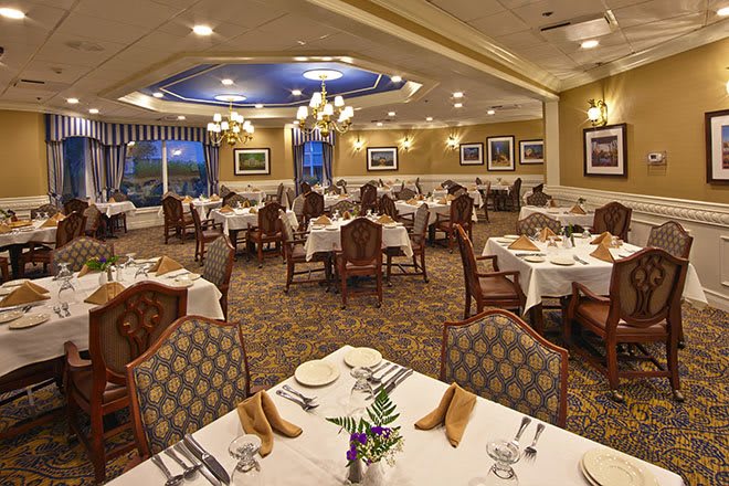 An elegant restaurant dining room with well-arranged tables and chandeliers.