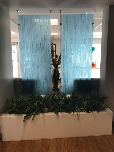 A stylish water feature complemented by blue curtains and decorative plants.