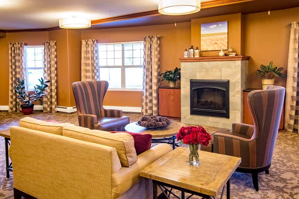 A cozy living room with a sofa, armchairs, and a fireplace.