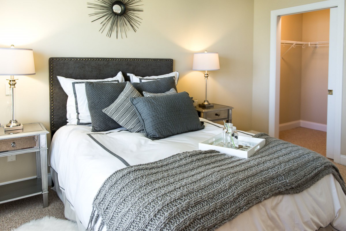 A cozy and modern bedroom with stylish gray bedding and decorative pillows.
