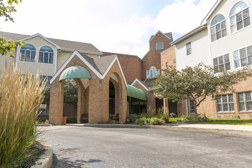 A welcoming entrance to a residential building, featuring distinct architectural elements and lush greenery.