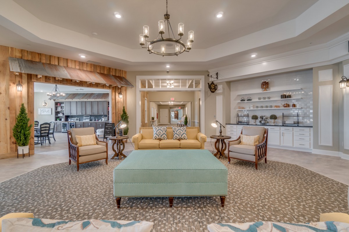 An elegantly designed living room with a central chandelier, comfortable seating, and tasteful decor.
