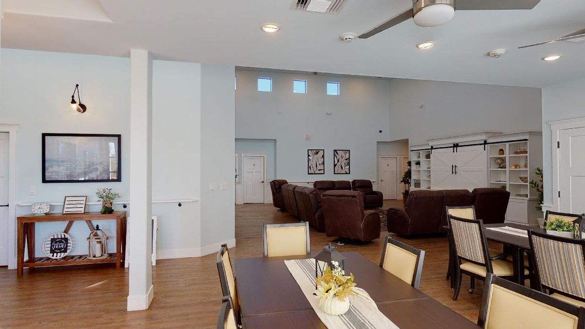 A modern open living and dining area with comfortable seating and a wooden floor.