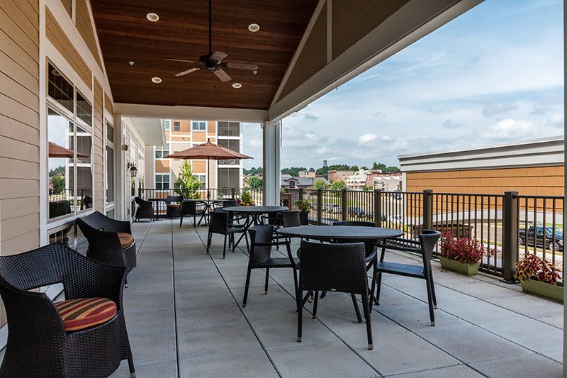A modern outdoor patio with tables and chairs overlooking a cityscape.