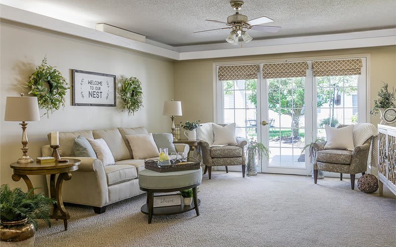 A cozy and well-decorated living room with comfortable seating and large windows.