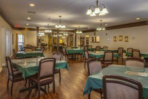 A cozy restaurant dining room with elegantly set tables and warm lighting.