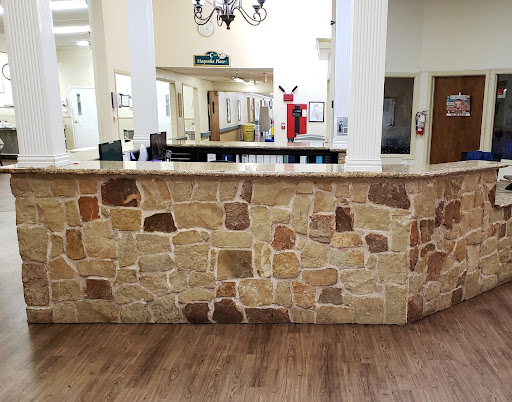 A reception area featuring a stone counter and wooden flooring.