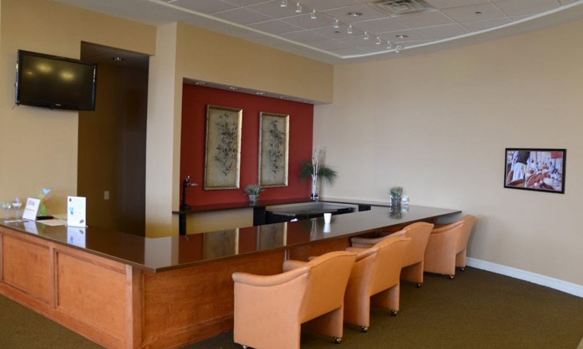 A well-appointed conference room featuring a long table, several chairs, and wall artwork.
