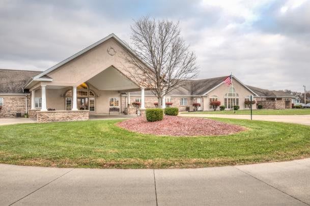 A suburban building with a landscaped lawn and a cloudy sky.