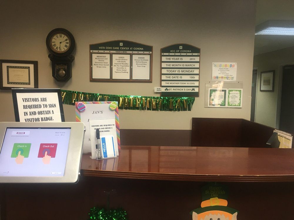 A reception desk with signage, a digital kiosk, and various decorations.