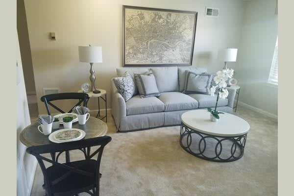 A cozy living room with a comfortable sofa, elegant coffee table, stylish lamps, and decorative wall art.