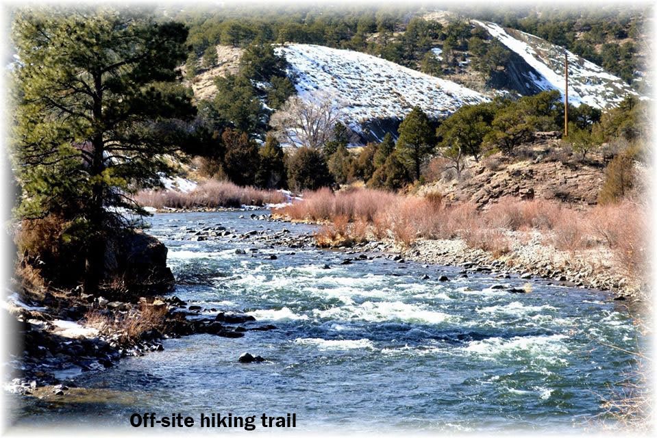 A scenic river flowing through a mountainous hiking trail.