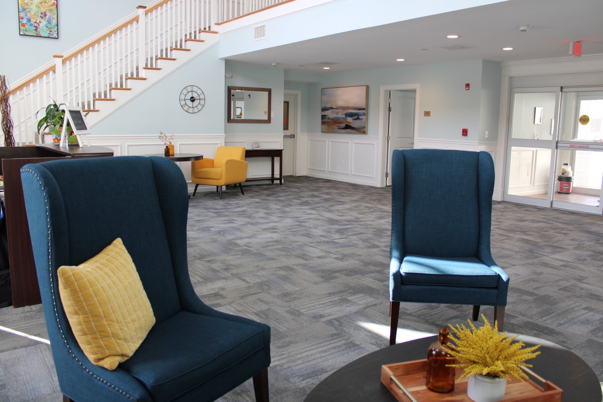 A modern lobby with stylish furniture and a staircase.
