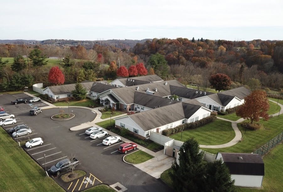 Aerial view of a residential area surrounded by autumn trees.
