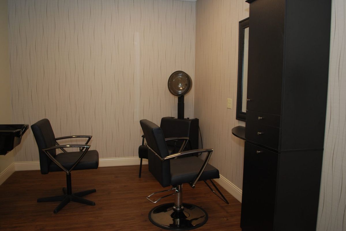 A modern hair salon interior with chairs and a hair dryer.