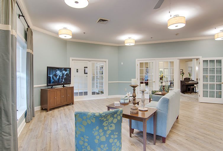 A cozy living room with elegant decor, featuring a TV, sofa, and comfortable seating.