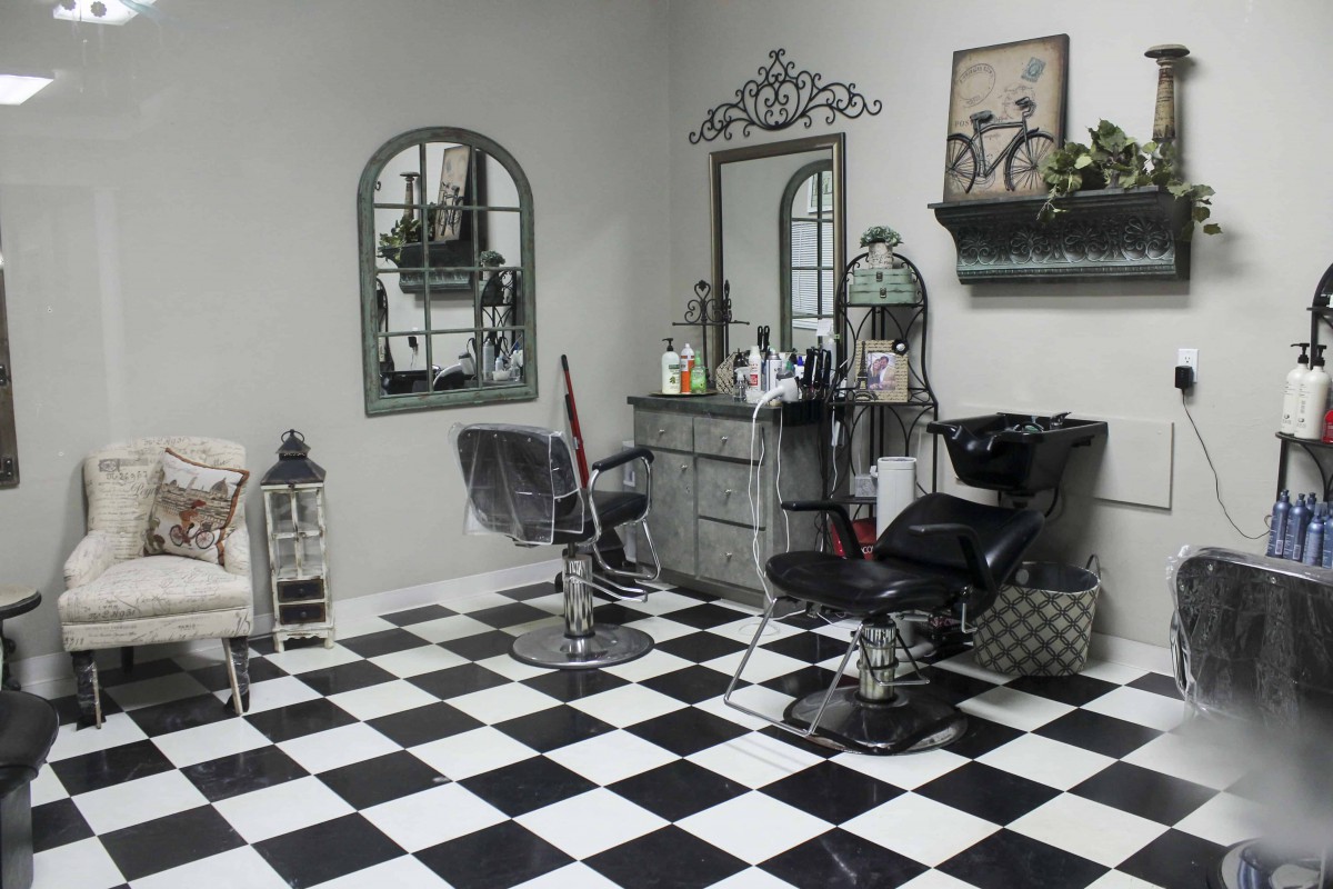 A stylish barber shop interior with checkered flooring and various salon equipment.