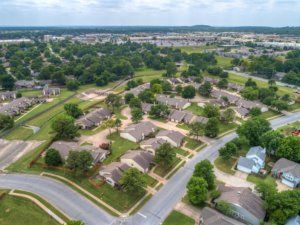 An aerial view of a suburban neighborhood with houses and greenery.
