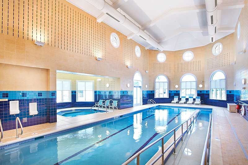 A luxurious indoor swimming pool with natural lighting and a relaxation area.