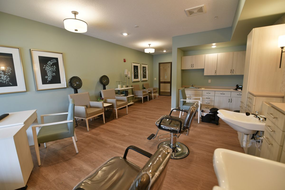 A modern salon interior with styling chairs, mirrors, and a waiting area.