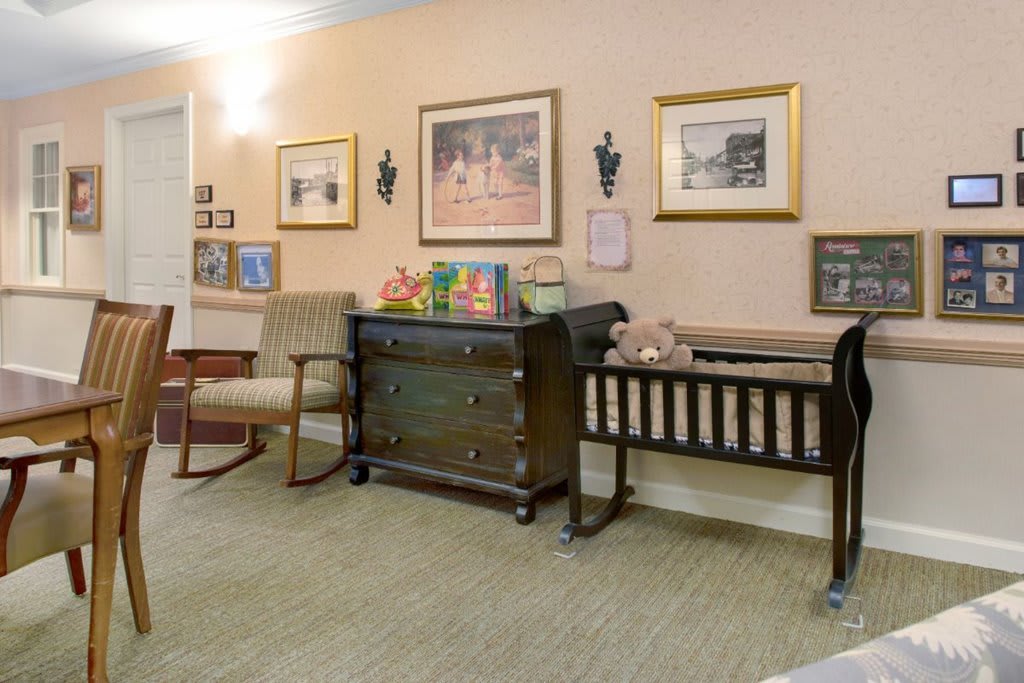 A cozy nursery with a crib, rocking chair, and decorative wall art.